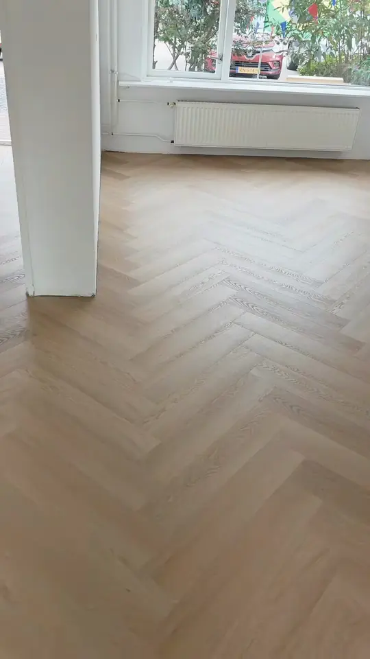 Warme visgraatvloer in een lichte kamer